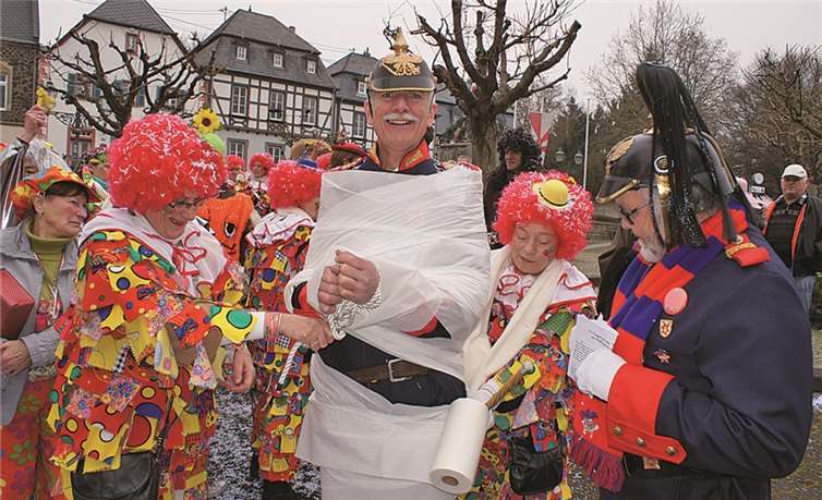 Kurzerhand wurde Ortsbürgermeister Arno Schmitz von den siegreichen Möhnen in weißes Leinen eingepackt. Sein Amtsvorgänger und Kommandant der Bürgerwehr Jürgen Häfner staunte nicht schlecht.
