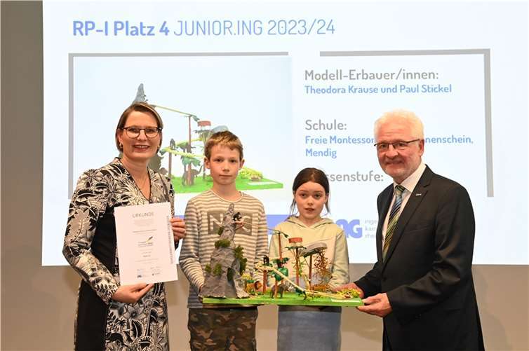 Landespreisverleihung Junior.ING in Mainz: Bildungsministerin Dr. Stefanie Hubig (links) und Kammerpräsident Dr. -Ing. Horst Lenz (rechts) ehrten Paul Stickel (2.v.l.) und Theodora Krause (3.v.l.) mit ihrem Achterbahnmodell „Le train de la jungle“ zum 4. Platz in der Altersklasse I.