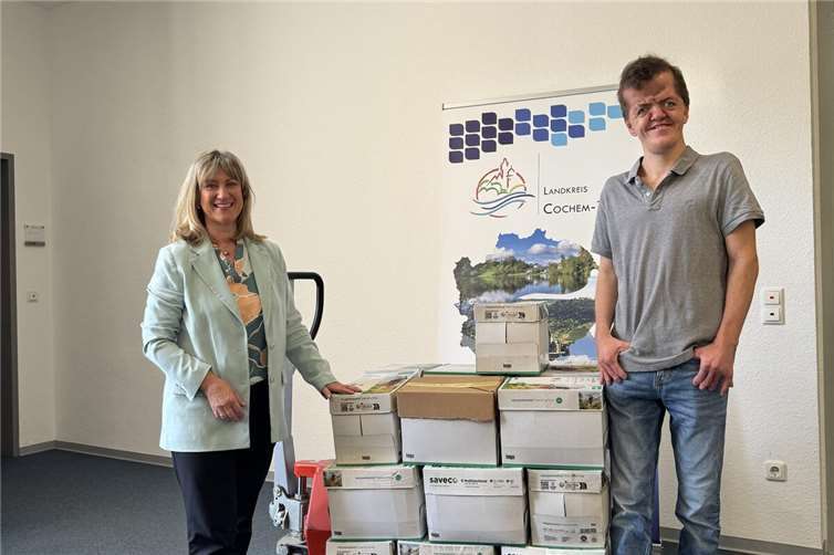 Landrätin Anke Beilstein übergibt 22 Kartons mit Kronkorken an Adrian Justen. Foto: Sophie Sesterhenn | Kreisverwaltung Cochem-Zell