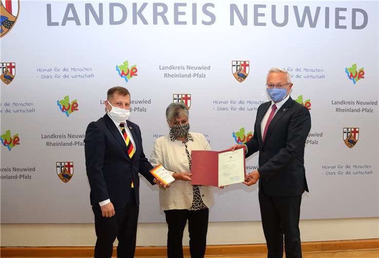 Landrat Achim Hallerbach (rechts) überreicht der Neuwieder Jazz- und Soulsängerin Shama Abbas die Einbürgerungsurkunde.