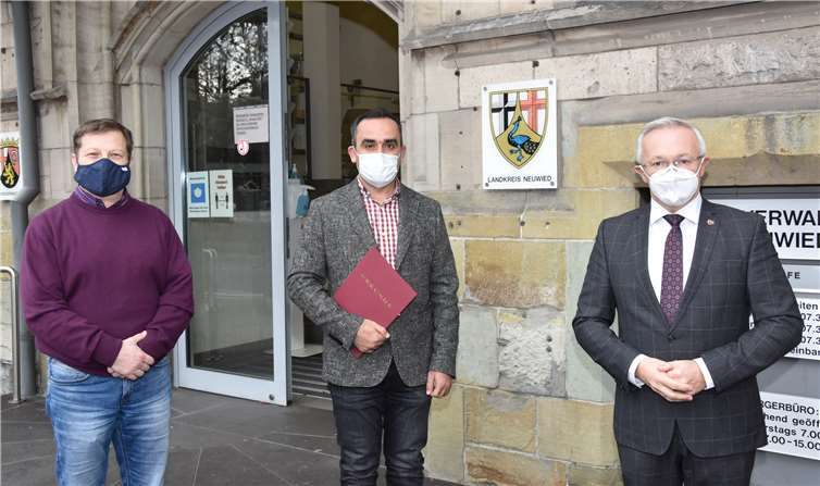 Landrat Achim Hallerbach (rechts) überreichte die Einbürgerungsurkunde an Abdulmunem Albatran. Als syrischer Flüchtling in den Landkreis Neuwieg gekommen, ist der Linzer dort und im gesamten Kreis bestens integriert. Zur Zeit absolviert er seine Ausbildung zum Verwaltungsfachangestellten in der Kreisverwaltung Neuwied. Mit auf dem Foto: Klaus Flesch (links) der die Einbürgerungen bei der Kreisverwaltung organisiert.