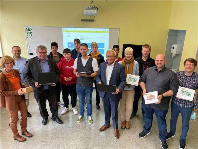 Landrat Achim Hallerbach und Kreis-Beigeordneter Michael Mahlert (jeweils mit Latop) sowie die stellvertretende Leiterin der Schulabteilung des Kreises (links) und der Digital-Beauftragte Karsten Rodigast (7. von links) freuen sich mit Schülern und Lehrern über die Verbesserung der technischen Ausstattung.Foto: Kreisverwaltung Neuwied