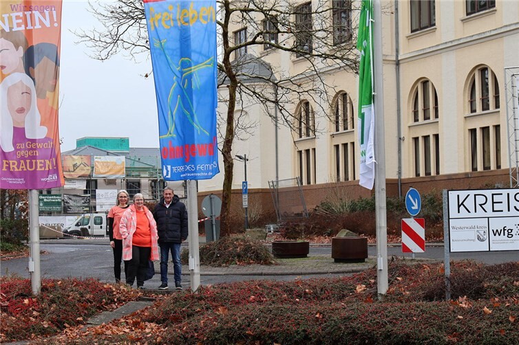 Landrat Achim Schwickert setzt gemeinsam mit der Gleichstellungsbeauftragten des Westerwaldkreises Beate Ullwer (Mitte) und ihrer Stellvertreterin Bianca Westphal mit den gehissten Fahnen ein Zeichen „NEIN zu Gewalt“. Foto:Kreisverwaltung / Carolin Faller