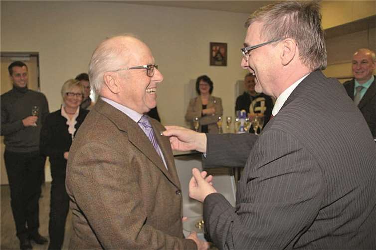 Landrat Dr. Alexander Saftig bei der Anbringung der Ehrennadel am Revers von Karl-Josef Kohl. Zum Wappenteller gehört eine Nadel, die am Revers getragen wird.