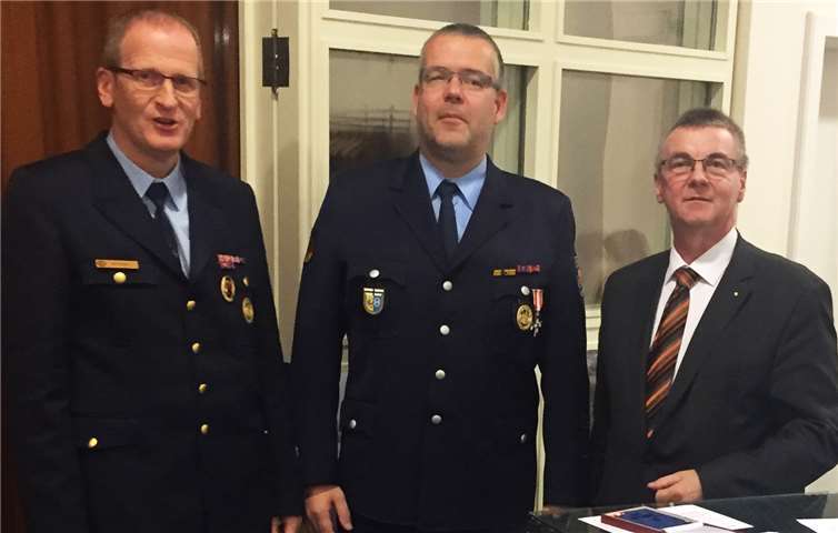 Landrat Dr. Alexander Saftig (rechts) und Kreisfeuerwehrinspekteur Rainer Nell (links) freuen sich mit Hauptbrandmeister Holger Neumann (mitte) über die Auszeichnung mit dem silbernen Feuerwehrehrenzeichen am Bande.privat