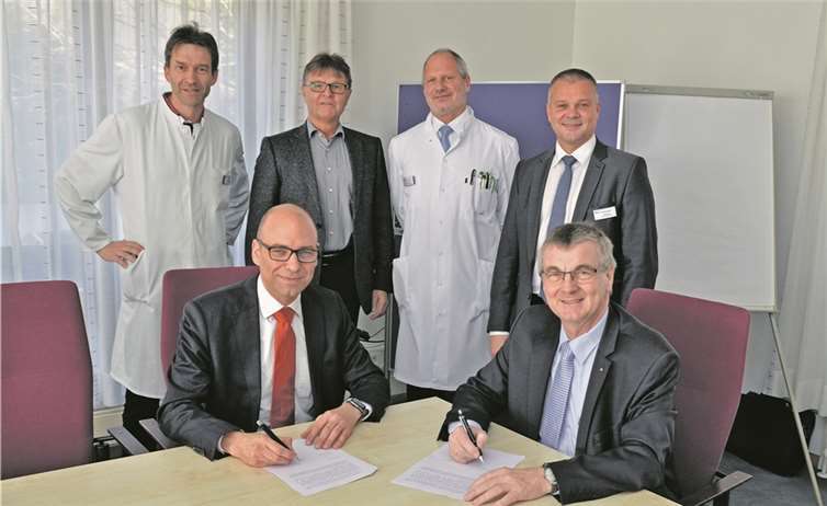 Landrat Dr. Alexander Saftig (rechts) und der Kaufmännische Geschäftschäftsführer des Gemeinschaftsklinikums Martin Stein (links) unterzeichneten im Beisein von Dr. Ralph Rüdelstein, Chefarzt für Innere Medizin, dem Ersten Kreisbeigeordneten Burkhard Nauroth, dem Ärztlichen Direktor Dr. Michael Maasberg und Georg Kohl, Geschäftsführender Direktor (hinten von links), die Kooperationsvereinbarung zur Verbundweiterbildung.
