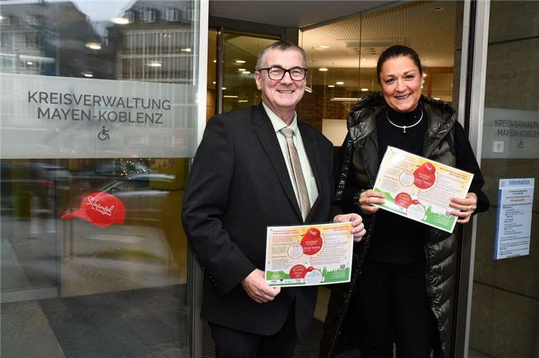 Landrat Dr. Alexander Saftig und Minka Bäumges vom Koblenzer Bündnis für Familien haben gemeinsam einen Aufkleber in Form einer roten Kappe mit der Aufschrift „Schängel in Sicherheit“ am Eingang des Kreishauses angebracht. Die Kreisverwaltung ist somit fortan gut als sicherer Ort für Kinder in Notsituationen erkennbar. Foto: Kreisverwaltung MYK/Damian Morcinek