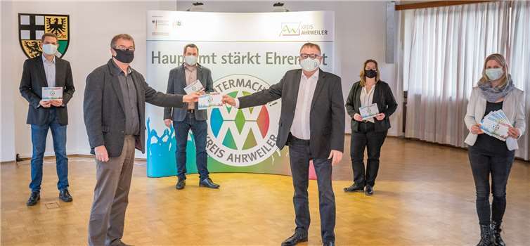 Landrat Dr. Jürgen Pföhler (3.v.r.) und der Leiter der KVHS, Michael Jacob (2.v.l.), stellen den Flyer zum bundesweit ersten Qualifizierungsangebot für Vereine „Ehrenamtsschule im Kreis Ahrweiler“ vor. Mit dabei: Projektleiter Mario Stratmann (3.v.l.), Michaela Wolff, Team „Weitermachen!“ (r.), Carmen Gros, stellv. Abteilungsleiterin Förderprogramme/Landwirtschaft (2.v.r.) und Christian Hofeditz (l.), stellv. Leiter der KVHS.Foto: Kreisverwaltung Ahrweiler / Bernhard Risse