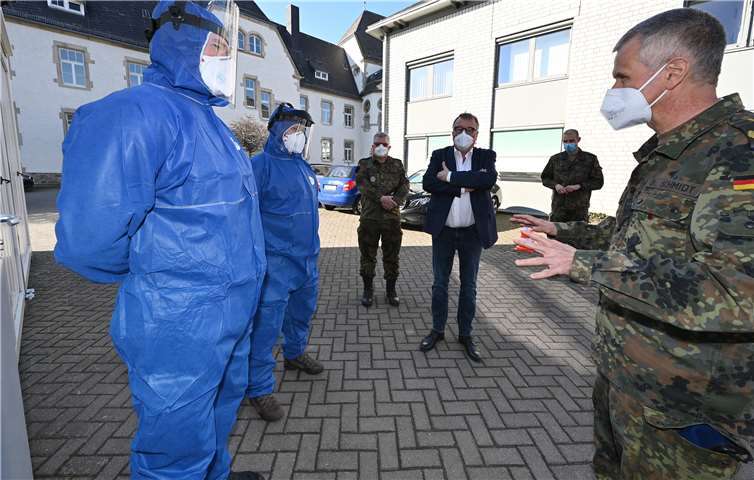Landrat Dr. Jürgen Pföhler (Mitte) und Generalstabsarzt Dr. Stephan Schmidt (rechts) im Gespräch mit zwei Soldaten, die im Corona-Abstrichzentrum in Grafschaft-Gelsdorf eingesetzt sind.Foto: Kreisverwaltung / Ralf Schuhmann