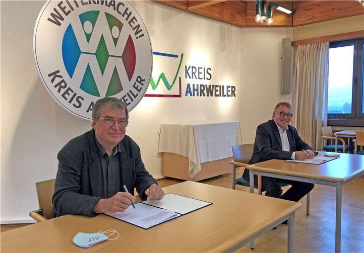 Landrat Dr. Jürgen Pföhler (r.) und Michael Jacob, Leiter der Kreisvolkshochschule, unterzeichnen den Vertrag. Foto: Kreisverwaltung