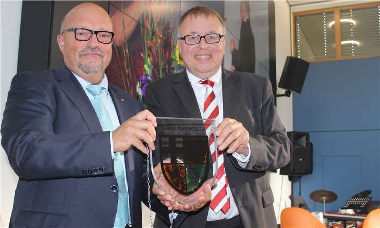 Landrat Dr. Jürgen Pföhler (rechts) übergab Akademieleiter Thomas Mitschke zur Eröffnung des neuen AKNZ-Schulungsgebäudes das Wappen des Kreises Ahrweiler. DU