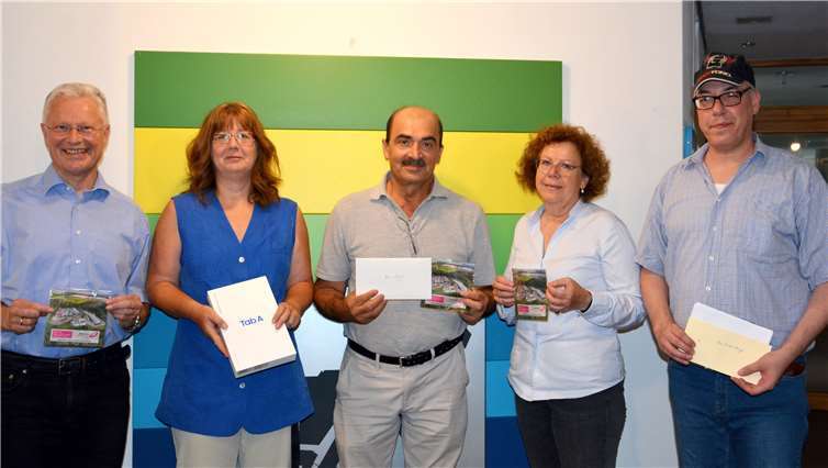 Landrat Frank Puchtler (links) und Inge Schwantuschke (zweite von rechts) vom Eigenbetrieb Abfallwirtschaft, die den Gewinnern des Gewinnspiels beim Tag der offenen Tür im Abfallwirtschaftszentrum Rhein-Lahn, gratulierte. Foto: Uwe Rindsfüßer