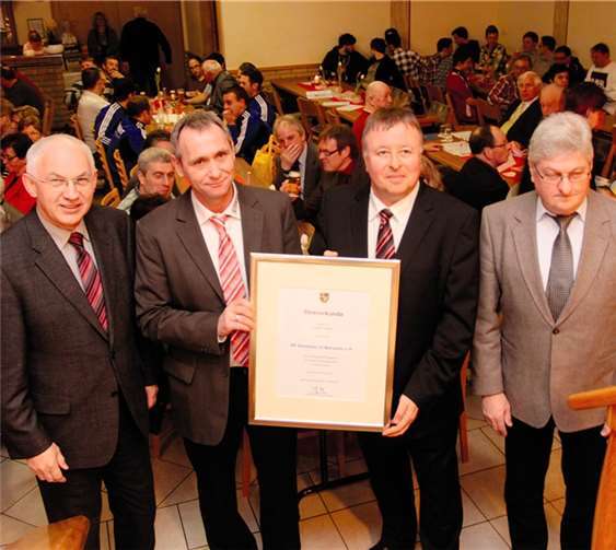 Landrat Jürgen Pföhler (2.v.r.) überreicht im Beisein von Bürgermeister Hermann Josef Romes (l.) und Ortsbürgermeister Walter Friedrichs (r.) die Ehrenurkunde des Kreises an den Vorsitzenden, Jürgen Fleischer.