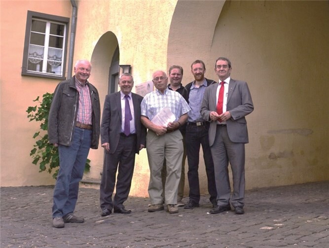 Landrat Manfred Schnur (2. v. r.) übergibt die Förderzusagen von Bund und Land an Ortsbürgermeister Manfred Ostermann (mitte). Bürgermeister Helmut Probst (rechts) freut sich mit der Gemeinde über die Zuwendungen. Privat