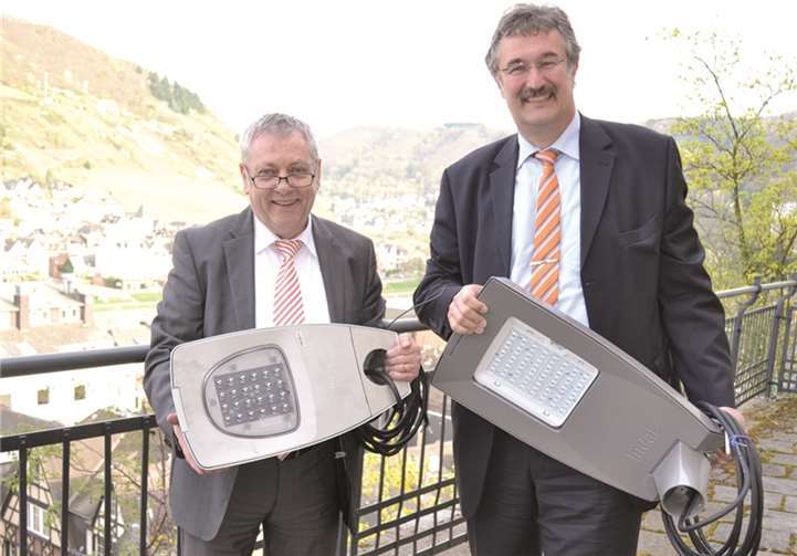 Landrat Manfred Schnur und Dr. Lothar Oelert, Leiter Rheinland-Pfalz im Bereich Konzessionen/Kommunen bei RWE mit zwei LED-Leuchten-Typen, wie sie in der Musterstraße in Müden installiert sind.privat