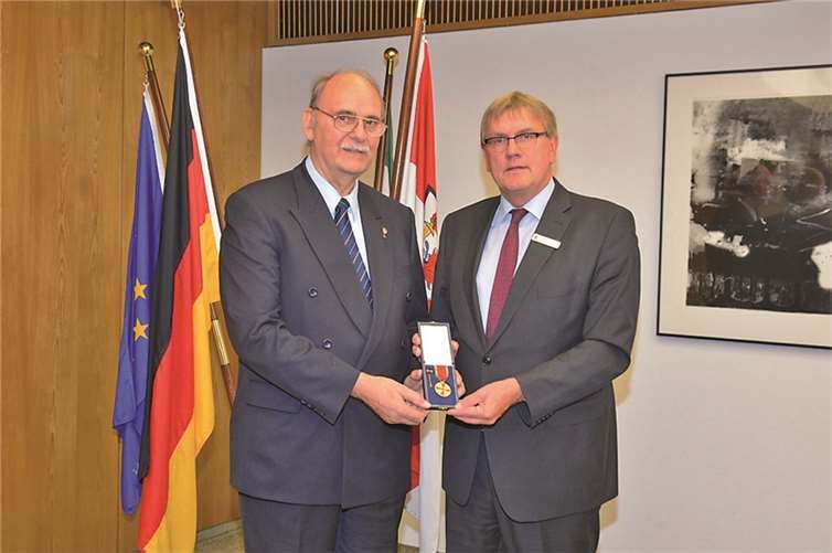 Landrat Schuster (r.) überreicht Karl Heinz Stocksiefen die vom Bundespräsidenten verliehenen Ordensinsignien.privat