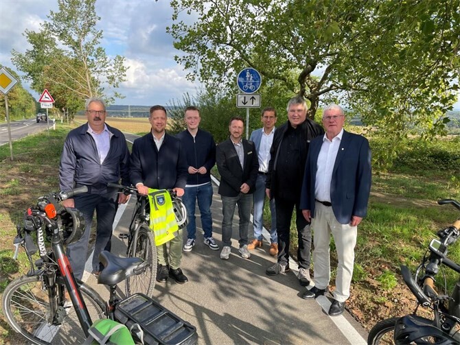 Landrat Sebastian Schuster (1.v.r.) und Bürgermeister Swen Christian (2.v.l.) gemeinsam mit Tim Hahlen, Verkehrsdezernent des Rhein-Sieg-Kreises (3.v.r.), Patrick Andres, Leiter Stabsstelle Kreisstraßenbau (4.v.r.), Ingo Steiner, Kreistagsmitglied aus Wachtberg und verkehrspolitischer Sprecher GRÜNE (2.v.r.) sowie Christoph Fievet, Kreistagsmitglied aus Wachtberg (1.v.l.) und Otis Henkel, Kreistagsmitglied aus Wachtberg (3.v.l.), bei der Einweihung des Lückenschlusses des Radwegs entlang der K 58, sowie ein Teilstück des fertig gestellten Radwegs an der K 58. Foto: Gemeinde Wachtberg