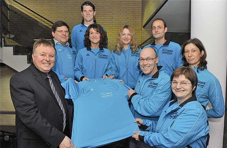 Landrat und Läufer: Dr. Jürgen Pföhler überreichte die Sportkleidung an die Laufgemeinschaft um Frank Heinen. KV-AW