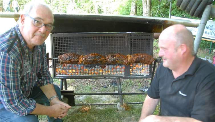 Raiffeisens Motto wurde beim Dorffest lebendig  Lange brutzelte der Spießbraten auf dem vonEckehard Kreten gebauten Drehspieß. Dorffest-Gourmetkoch Dirk Hachenberg (l.) und Ortsvorsteher Thomas Kretensorgten dafür, dass es eine runde Sache wurde.