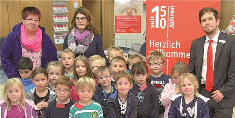 Lars Krämer (r.) von der Kreissparkasse Ahrweiler bot den Kindern und Betreuerinnen des katholischen Kindergartens Kempenich spannende Einblicke in die Sparkassengeschäftsstelle. privat