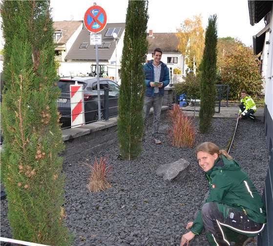 Lea Rüdell und Leon Rommersbach, beide angehende Landschaftsgärtner bei der Stadt Koblenz, nehmen im Vorgarten von Fabian Vocktmann und seiner Familie Maß. Der Schottergarten wird einem bunten Staudenbeet weichen.Quelle: Stadt Koblenz