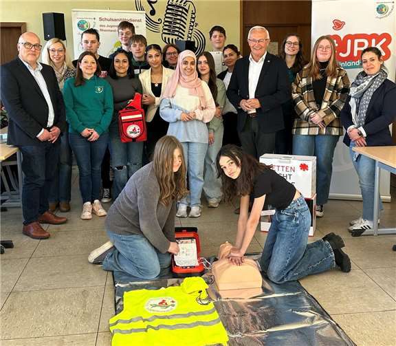 „Learning by doing (and teaching): Landrat Achim Hallerbach machte sich in der Robert-Krups-Schule im Neuwieder Stadtteil Irlich mit Schulleiter Peter Kowalenko selbst ein Bild vom Schulsanitätsdienst. Foto: Thomas Herschbach