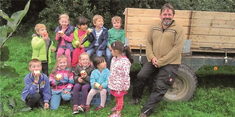 Lecker, so ein frischer Apfel direkt vom Obstbauern: Die Kita-Kinder mit Obstbauer Manfred Felten beim Picknick.Stadt Meckenheim