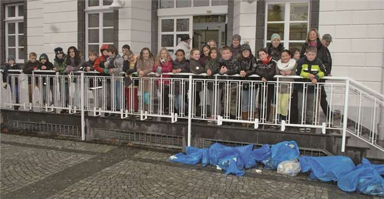 Leicht durchnässt aber zufrieden: Die Saubermänner und Sauberfrauen der 4 c mit „Beute“ vor dem Sinziger Rathaus. BL