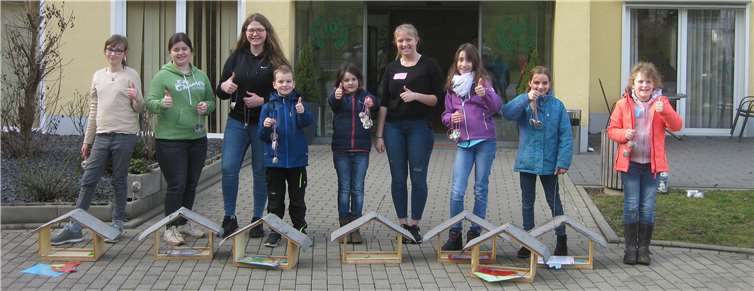 Lena Friedrich und Carolin Rothbrust posieren stolz mit einigen TeilnehmerInnen und den fertigen Vogelhäuschen für das Gruppenfoto. Foto: privat