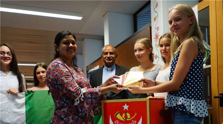 Leonie Fischbach (8c) übergibt die Briefe nach Pakistan an Sana Iqbal.