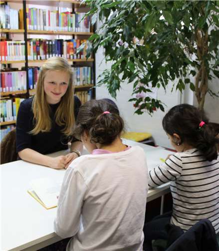 Lesepatin Sophie Ueter beim intensiven Lesen mit zwei künftigen „Vielleserinnen“. Foto: Bürgerstiftung Bad Ems