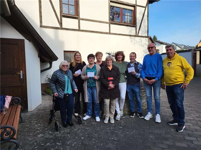 Letzte Übergabe aus dem Adventstreffen. Diesmal erreichte der Erlös einige ansässige Vereine zur Förderung der Ortsgemeinschaft. Die Gruppe Verantwortlicher am Ortsbrunnen, neben dem Backes in der Ringstraße.  Foto: Nicole Wolter