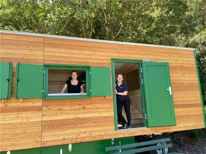 Lisa Reichert, Johanniter Mittelrhein und Lisa Thies vom Kinderschutzbund am Bauwagen des neuen Waldkindergartens in Rech/Dernau. Dieser wird den Kindern bei schlechtem Wetter als Unterschlupf dienen.  Foto: Mann Metallrecycling