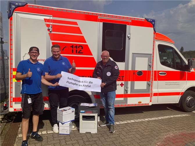Logistikmitarbeiter Timo Keller und Maximilian Ellinger, Mitglied der Geschäftsleitung der Firma NKS, NOTHNAGEL GmbH & Co. Kommunikationssysteme KG, übergaben am Nürburgring an Armin Link (v. li.), Leiter des DRK-Einsatzteams Nürburgring, eine Sachspende über 47 Laserdrucker und 50.000 Blatt Papier für die DRK-Flutopferhilfe an der Ahr. Foto: Armin Link
