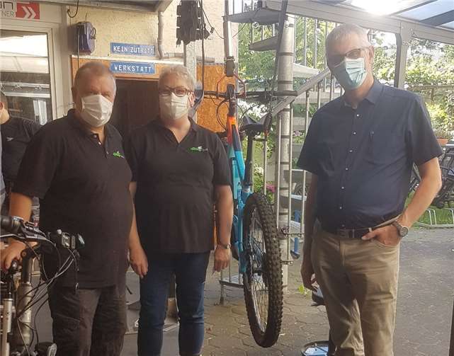 Ludger Banken begrüßt Merzbacher Gewerbetreibende, hier die Inhaber des Fahrradgeschäftes Pro-Cycling Golla.