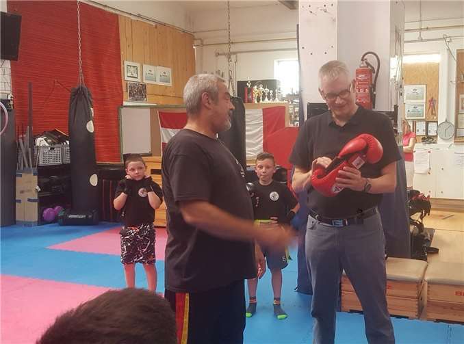 Ludger Banken (re.) freut sich über das von Cheftrainer Willi Zinken (li.) überreichte Willkommensgeschenk: Ein Paar signierte Boxhandschuhe. Foto: privat