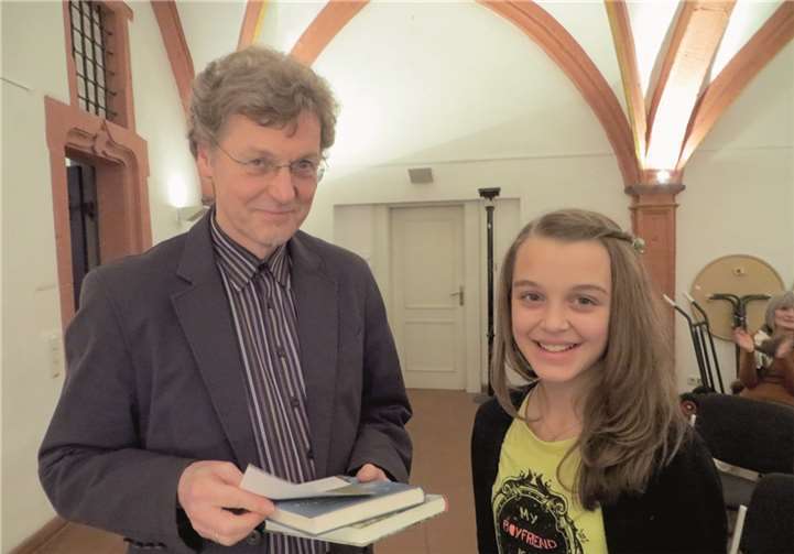 Luisa erhält die Kreissieger-Urkunde und ein Buch von Peter Buchen.