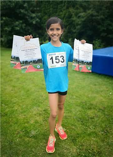 Luisa präsentiert ihre Urkunden.