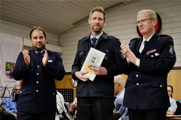 Lukas Reutelsterz (Mitte) wurde von Jens Nikolai (links), Vorsitzender des Kreisfeuerwehrverbandes Mayen-Koblenz, die Bronzene Ehrennadel des Landesfeuerwehrverbandes Rheinland-Pfalz verliehen. Rainer Nell (rechts), Brand- und Katastrophenschutzinspekteur (BKI) Mayen-Koblenz gehörte zu den Gratulanten.  Foto: Jan Fink/FFW Bell