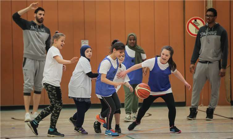 Mädchen der Klasse 6 und die Basketballprofis.