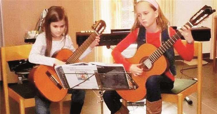 Mädchen spielen klassische Gitarre. KMS