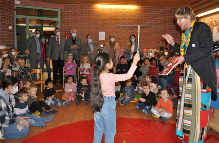 Magische Momente im Mosaik-Kulturhaus: Während sich die Kinder der Kita Villa Regenbogen von Nils Gruber verzaubern lassen, schauen die Gäste in der hinteren Reihe gespannt zu, von links: Hans Dieter Wirtz, Erster Beigeordneter, Kita-Leiterin Alexandra Dietz, Manfred Weizbauer, Joachim Krüger, Erhard Knauer und Marlies Maruschke, alle Lions-Club Bonn-Rhenobacum, und Anna Sitner, Leiterin der städtischen Jugendhilfe.Foto: Stadt Meckenheim
