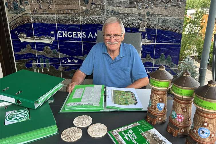 Manfred Brachtendorf an seinem Gartentisch. Vor sich aufgeschlagen liegt einer von fast 50 Ordnern, in denen er alle Artikel rund um den FV Engers gesammelt hat. Brachtendorf hat auch maßgeblich die Chronik zum 100-jährigen Vereinsjubiläum geschrieben. Zu jedem Erfolg fertig er Keramik-Medaillen an, zu besonderen Anlässen wie den DFB-Pokal-Spielen auch Wassertürme.Foto: Ulf Steffenfauseweh