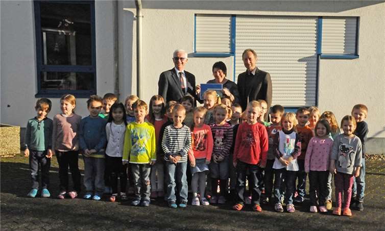 Manfred Breitbach, Vizegeschäftsführer der Unfallkasse, Ingrid Brabender Leiterin der Kita St. Katharinen, Hans Josef Weißenfels, erster Beigeordneter der Ortsgemeinde St. Katharinen und einigen Kindern bei der Übergabe der Geldprämie (v.l.).privat
