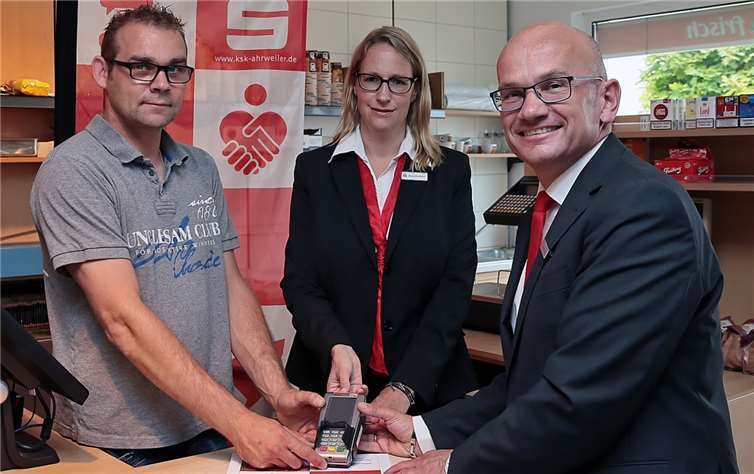 Manfred Klapperich (links), Inhaber des Hofladens in Wershofen, sowie Christoph Frings und Alexandra Müller präsentieren das neue Electronic-Cash-Terminal, das Kunden der Kreissparkasse Ahrweiler die Möglichkeit zur Bargeldversorgung und Kartenbezahlung bietet.privat
