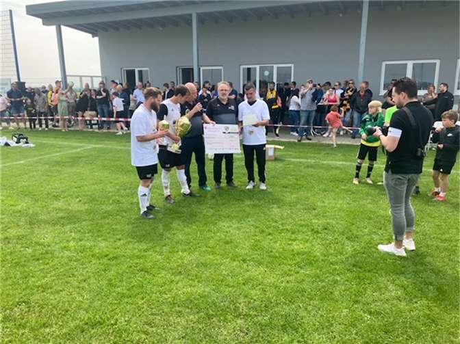 Mannschaftskapitän Marcel Schmitz sowie die Trainer Paddy Melcher und Dennis Schütz nahmen den Pokal, Urkunde, Siegertrikots und die Prämie i.H. von 500 Euro der Bitburger Brauerei durch Kreisvorsitzenden Sesterheim und Kreissachbearbeiter Frings stolz entgegen.