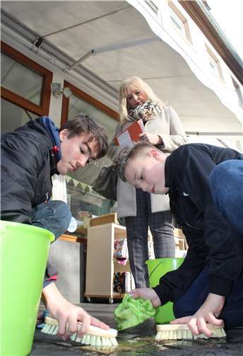 Manuel Nonn und Felix Odin Raschke von der Clemens-Brentano-/Overberg-Realschule plus Koblenz reinigen Stolpersteine nahe der Liebfrauenkirche. Kultur- und Schuldezernentin Dr. Margit Theis-Scholz erachtet die neuen Schulpatenschaften für Stolpersteine als wichtigen Beitrag für lebendige Erinnerungskultur.Stadt Koblenz