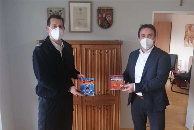 Marcel Caspers, Bürgermeister der Verbandsgemeinde Bad Breisig, übergibt Ronny Zilligen, Wehrleiter der Verbandsgemeinde Bad Breisig, die für die Bambini- und Jugendfeuerwehr bestimmten Fachbücher mit Wissen rund das Feuerwesen.Foto: VG Bad Breisig
