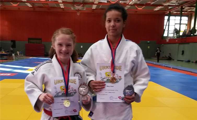 Marie Heeb und Mary Roth präsentieren stolz ihre Goldmedaillen.