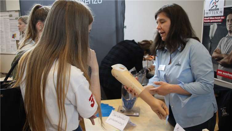 Marion Dum (rechts) vom Sanitätshaus Wittlich zeigt den Mädels eine Armprothese.